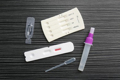 Photo of Disposable express test kits on black wooden table, flat lay