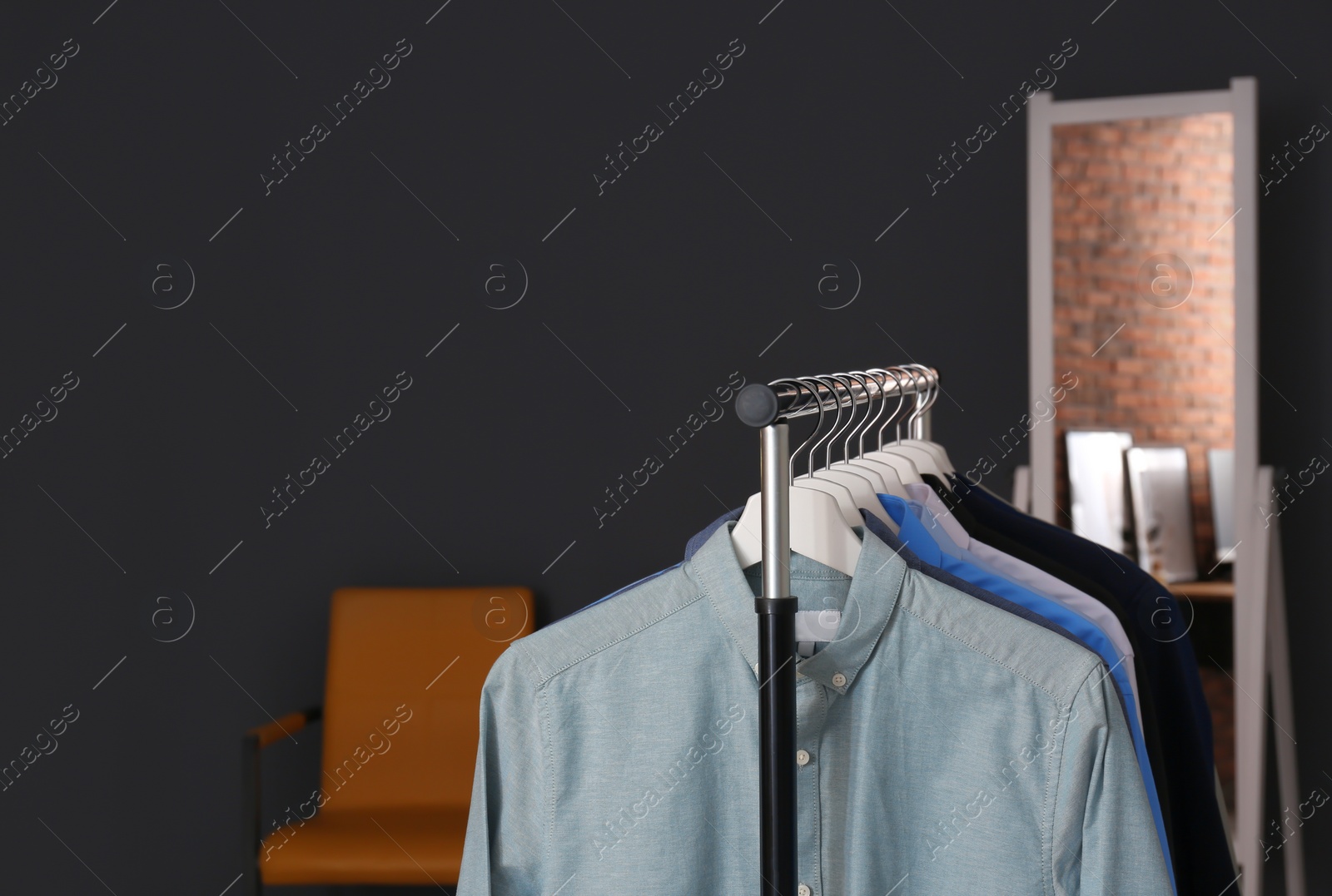 Photo of Wardrobe rack with stylish clothes in dressing room. Space for text
