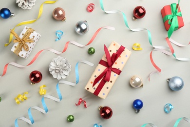 Flat lay composition with serpentine streamers and Christmas decor on light grey background