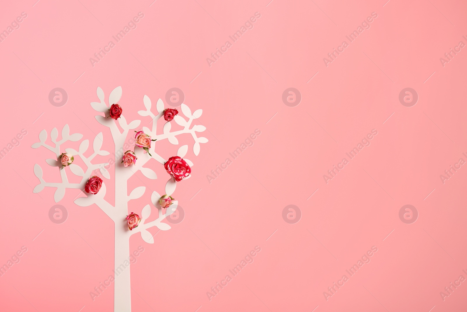 Photo of Decorative tree with flowers on color background, space for text