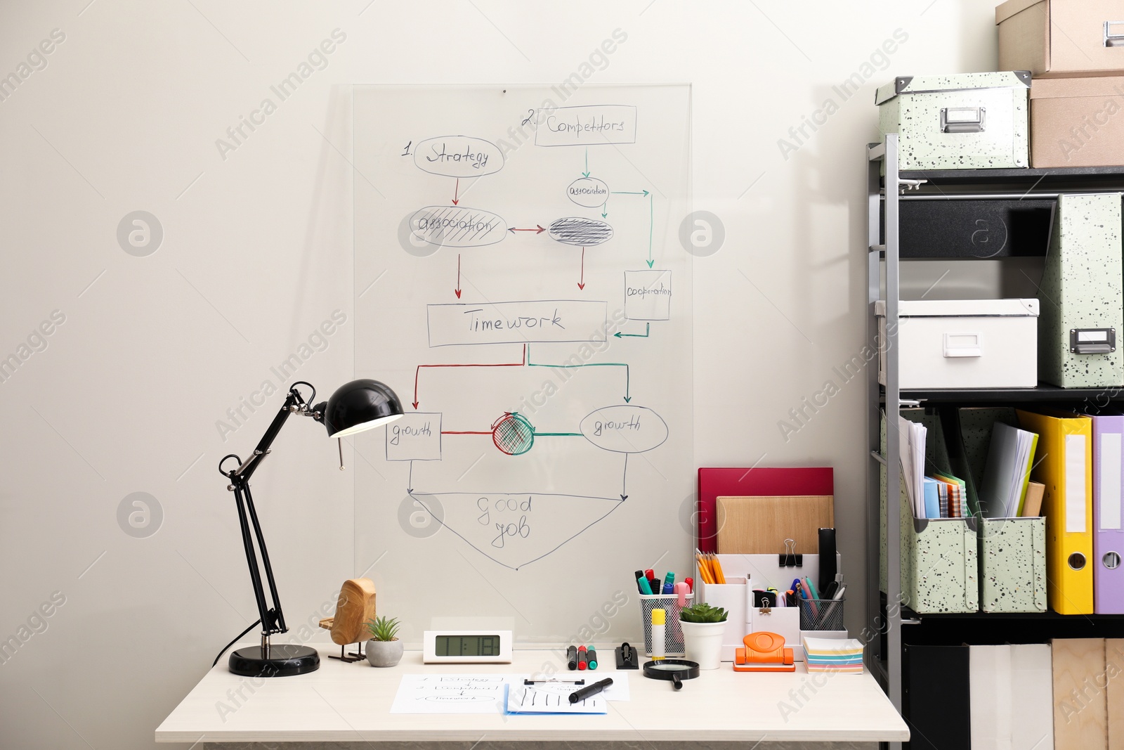 Photo of Business process planning and optimization. Workplace with lamp, notebook and other stationery on white wooden table