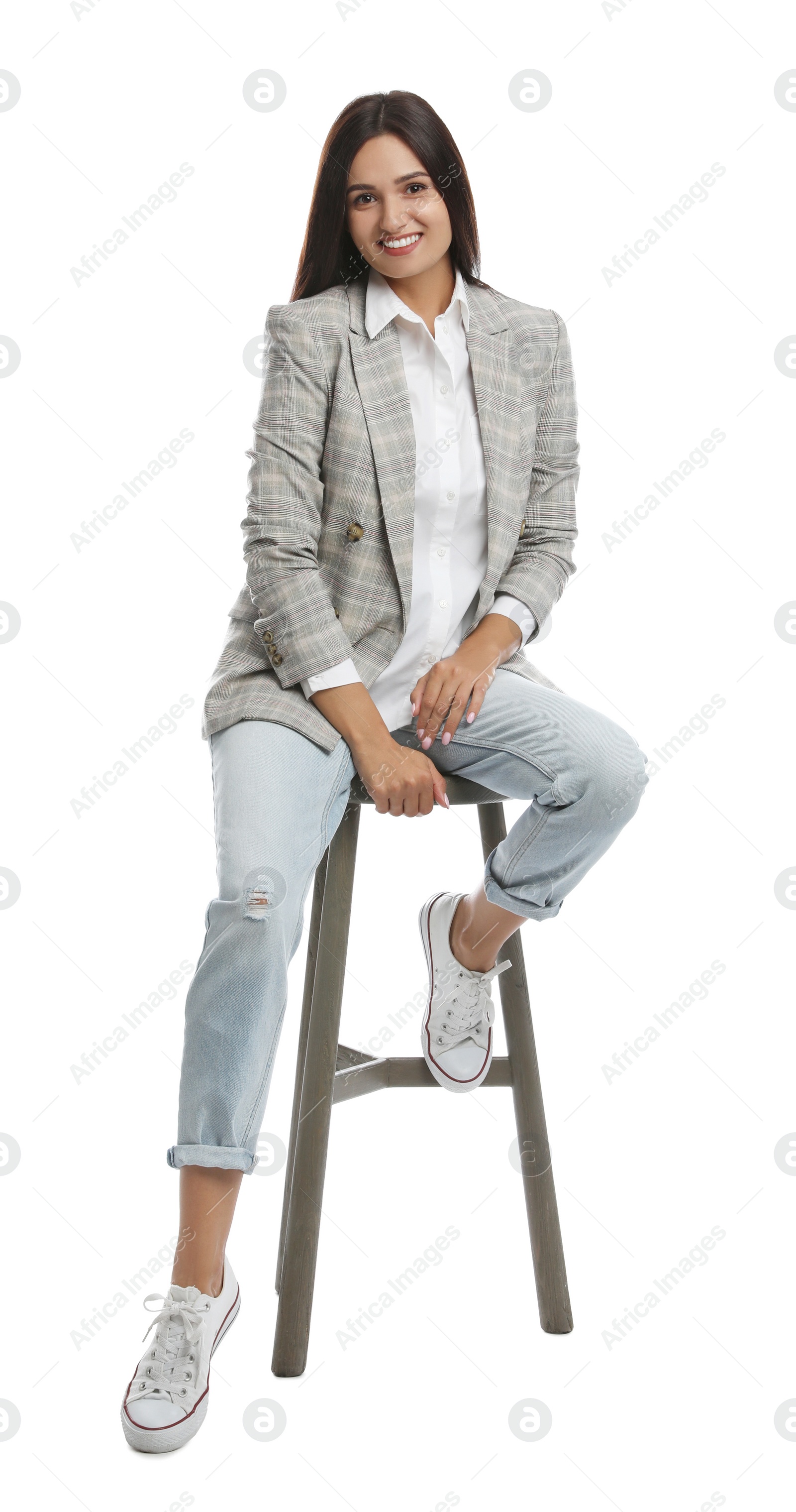 Photo of Beautiful young woman sitting on stool against white background