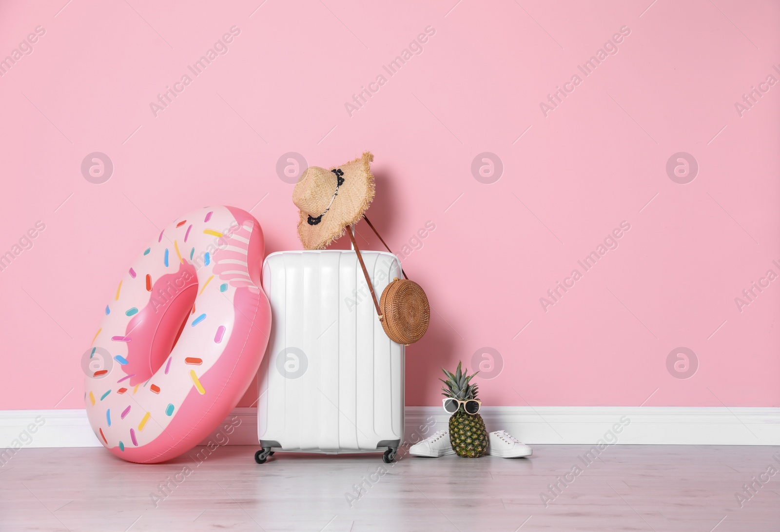 Photo of Large suitcase for travelling and beach items with space for text near color wall