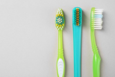 Photo of Many different toothbrushes on light background, flat lay. Space for text