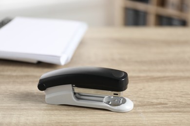 Photo of One stapler on wooden table indoors, closeup