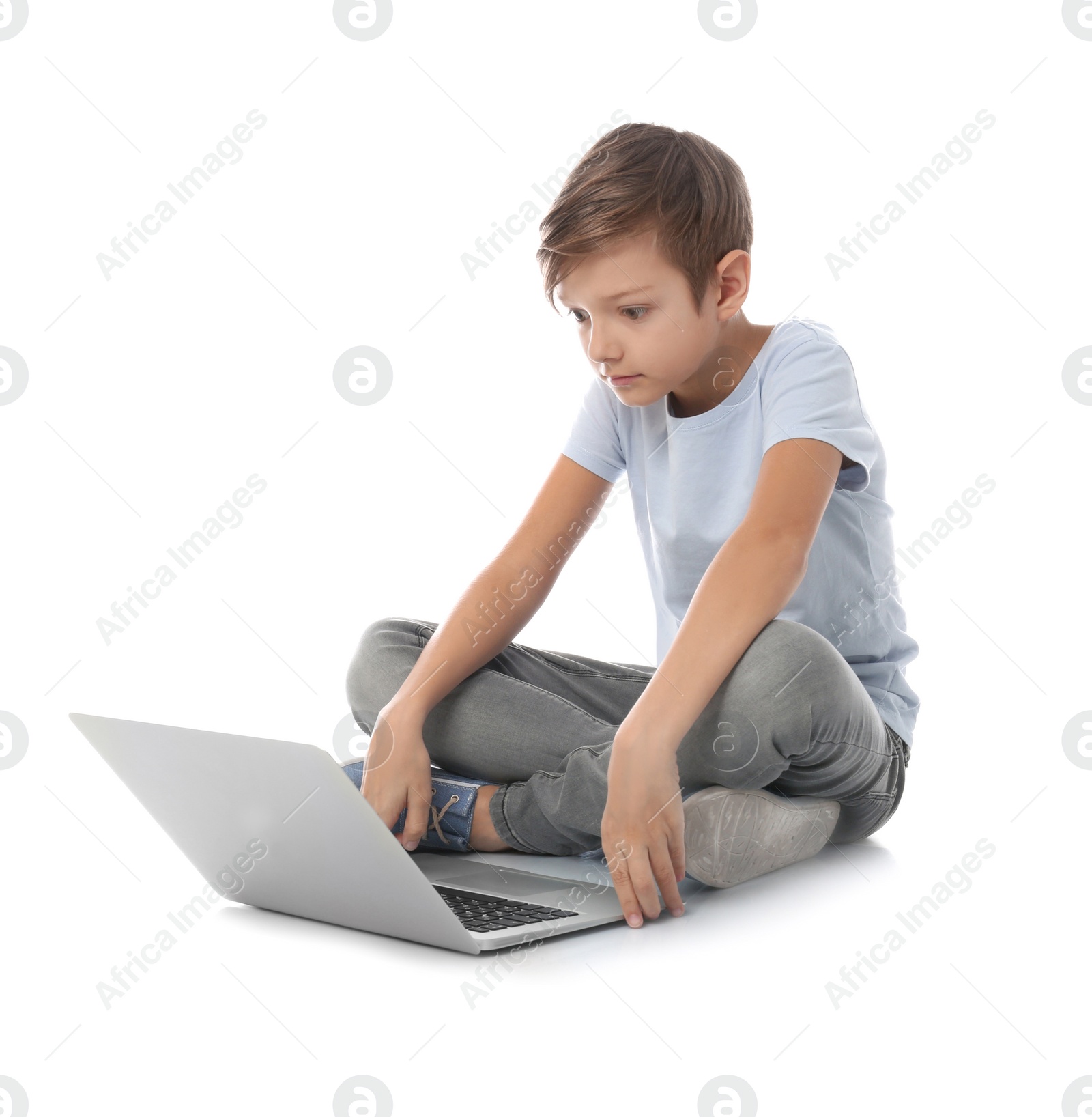 Photo of Shocked child with laptop on white background. Danger of internet