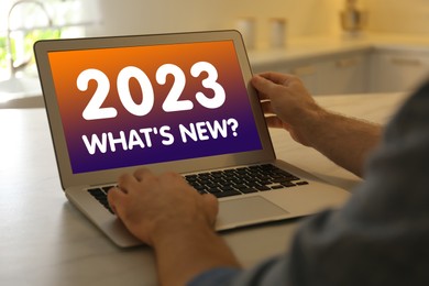 Image of Future trends. 2023 What's New? text on laptop display. Man using device, closeup