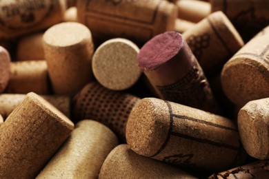 Photo of Many corks of wine bottles with grape images as background, closeup