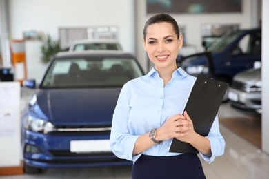 Portrait of young saleswoman in car dealership