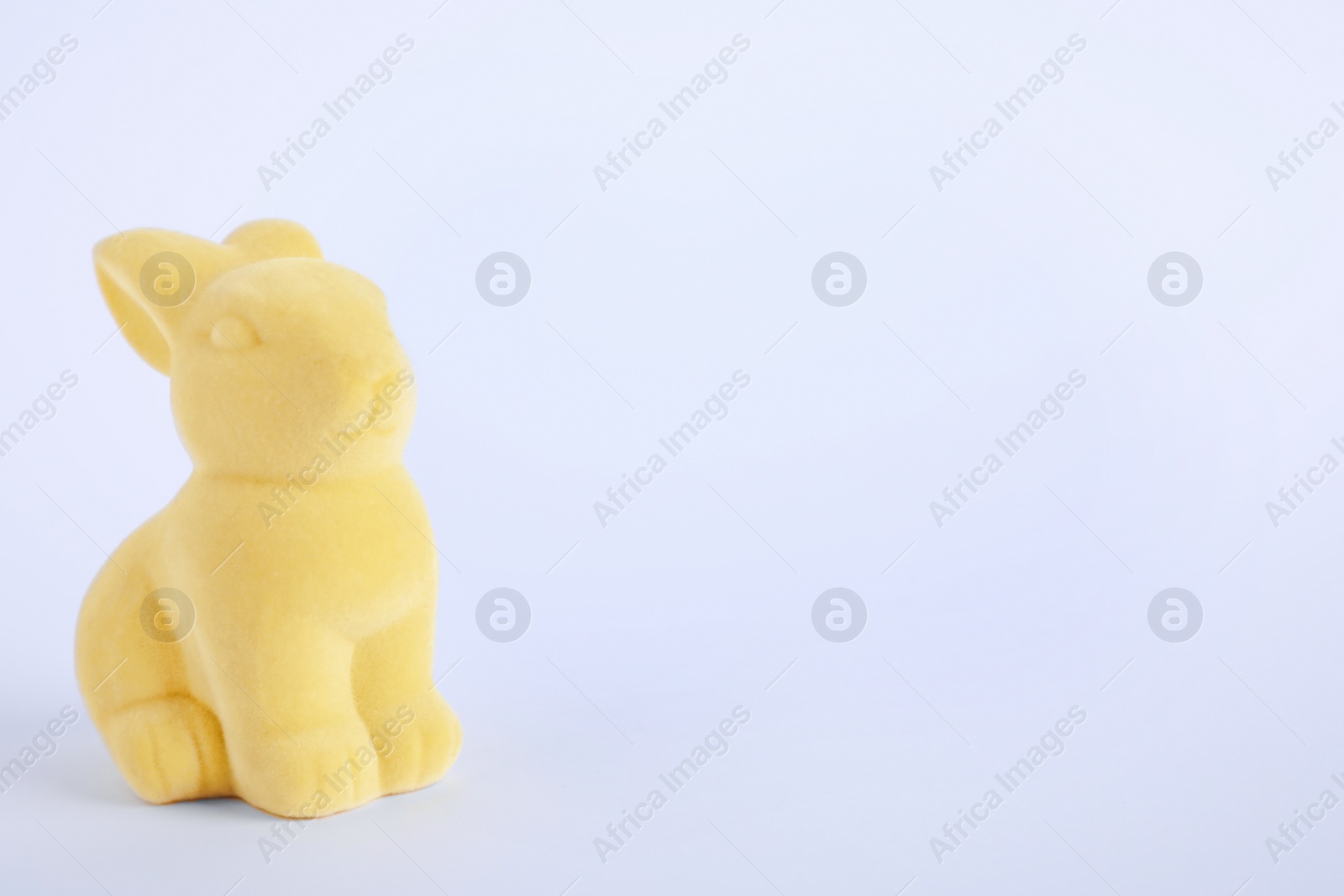 Photo of Easter bunny toy on white background. Space for text