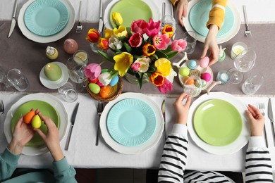 Photo of Festive table setting. Women celebrating Easter at home, top view