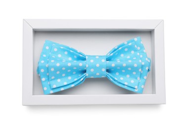 Stylish light blue bow tie with polka dot pattern in box on white background, top view
