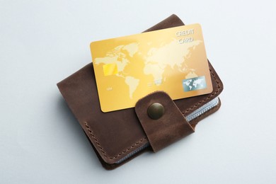 Photo of Woman holding leather card holder with credit card on light grey background