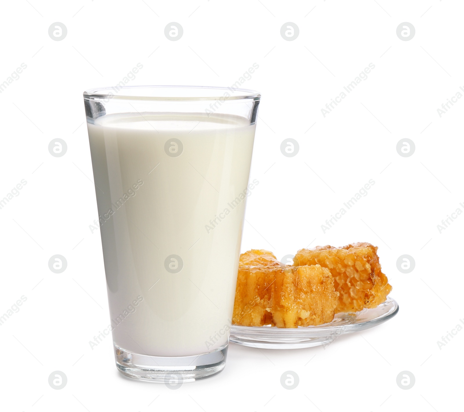 Photo of Glass with milk and honeycombs on white background