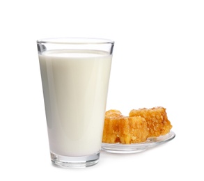 Photo of Glass with milk and honeycombs on white background