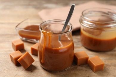 Tasty salted caramel and candies on wooden table