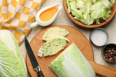 Photo of Fresh Chinese cabbages, oil and spices on light table, flat lay