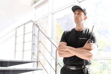 Male security guard with portable radio transmitter indoors