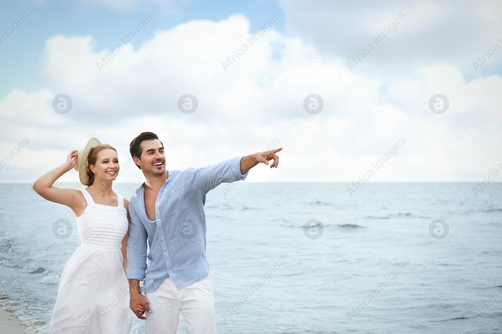 Photo of Happy young couple walking on sea beach