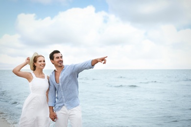 Photo of Happy young couple walking on sea beach