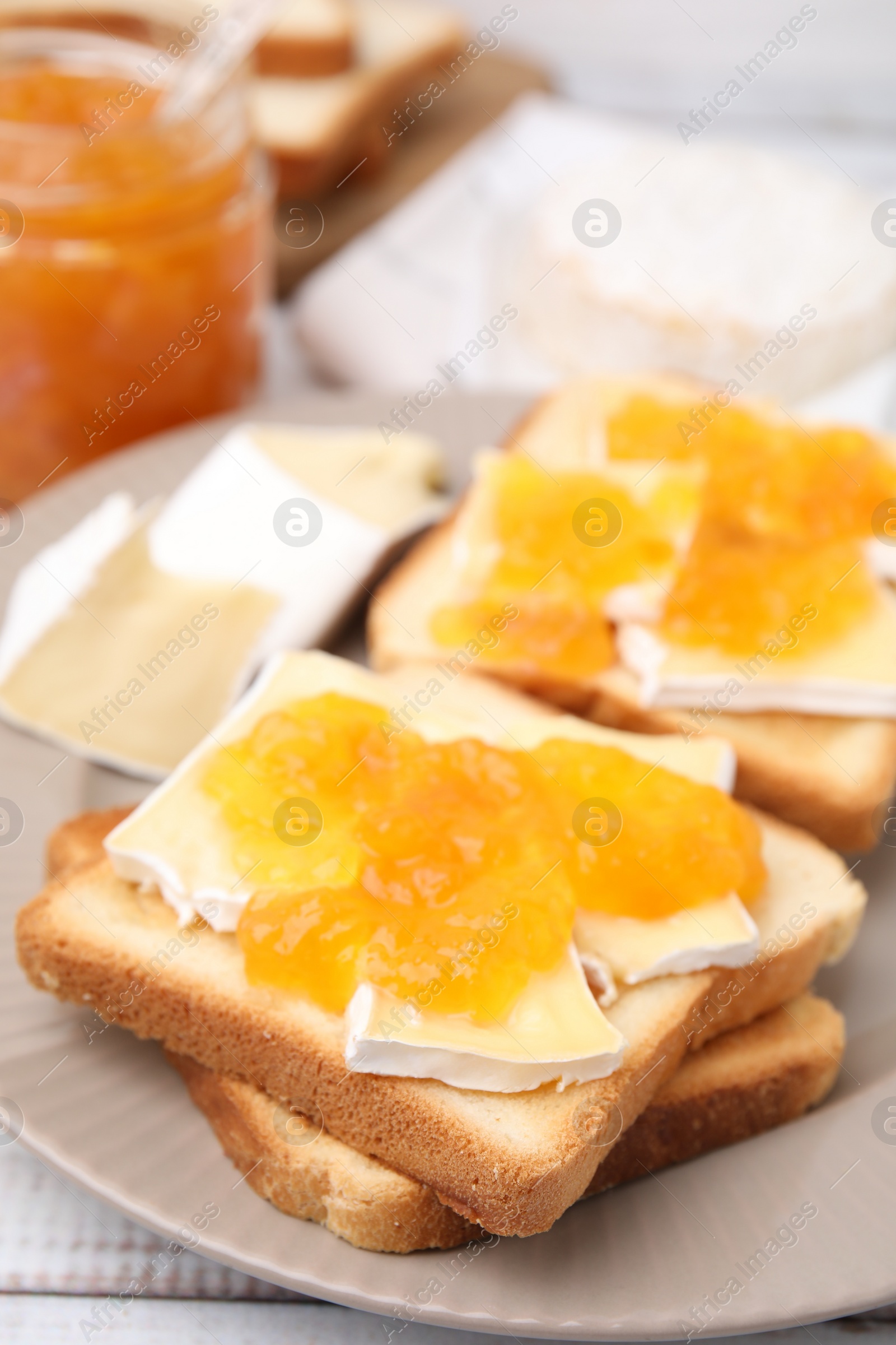 Photo of Tasty sandwiches with brie cheese and apricot jam on table, closeup