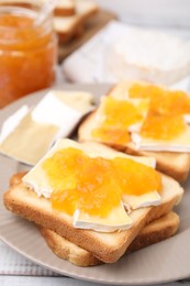 Tasty sandwiches with brie cheese and apricot jam on table, closeup