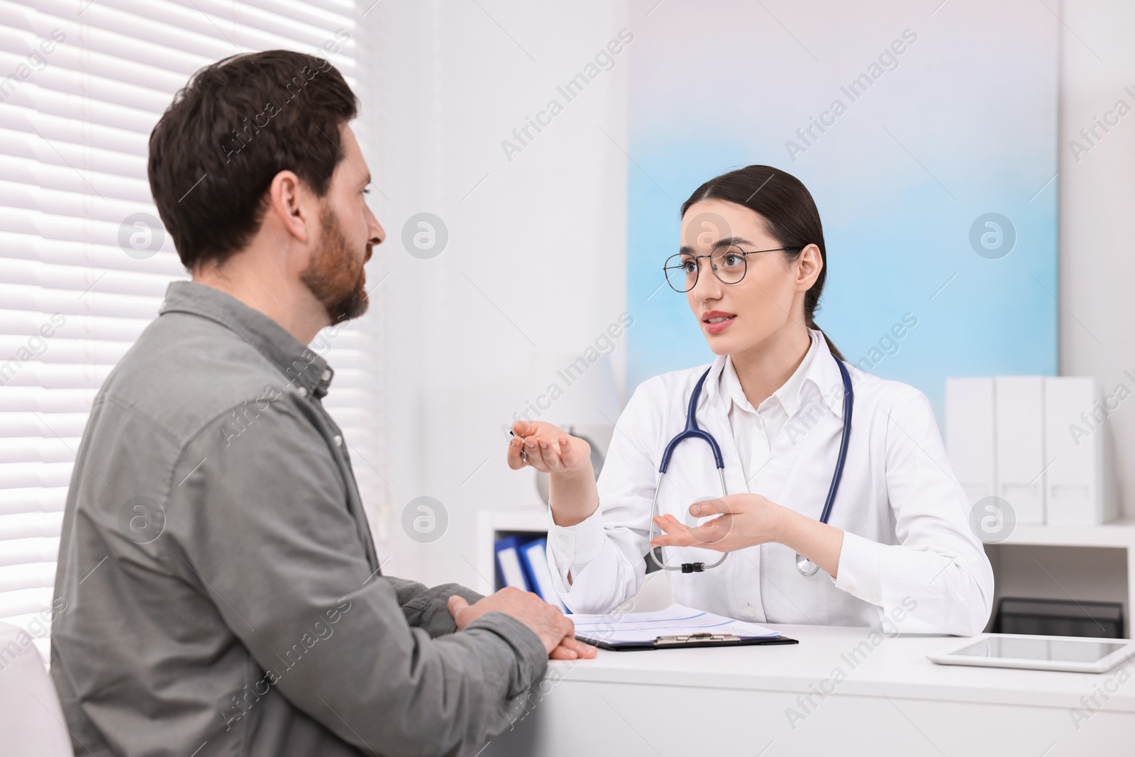 Photo of Doctor consulting patient during appointment in clinic