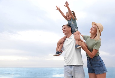 Photo of Happy family spending time together near sea on sunny summer day