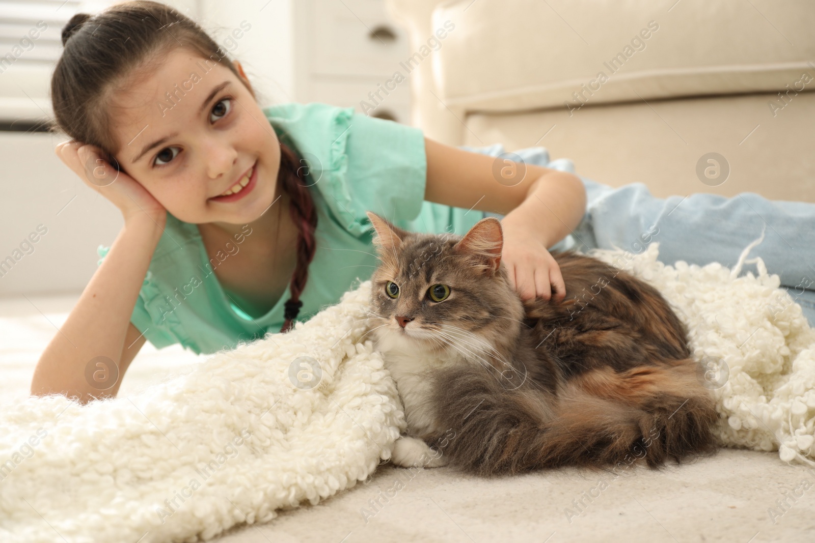 Photo of Cute little girl with cat lying on carpet at home. First pet