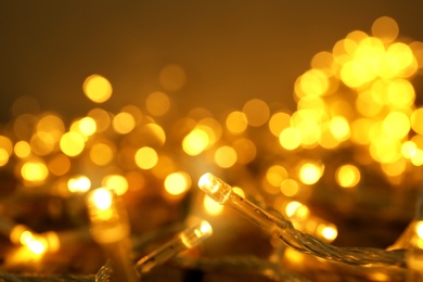 Glowing Christmas lights on table, closeup view