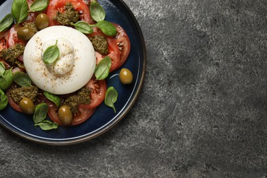 Photo of Delicious burrata salad on grey table, top view. Space for text