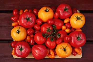 Photo of Many fresh tomatoes on wooden surface, top view
