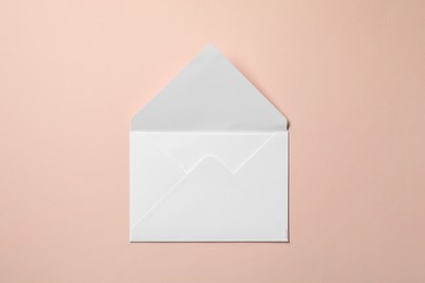 Letter envelope on beige background, top view