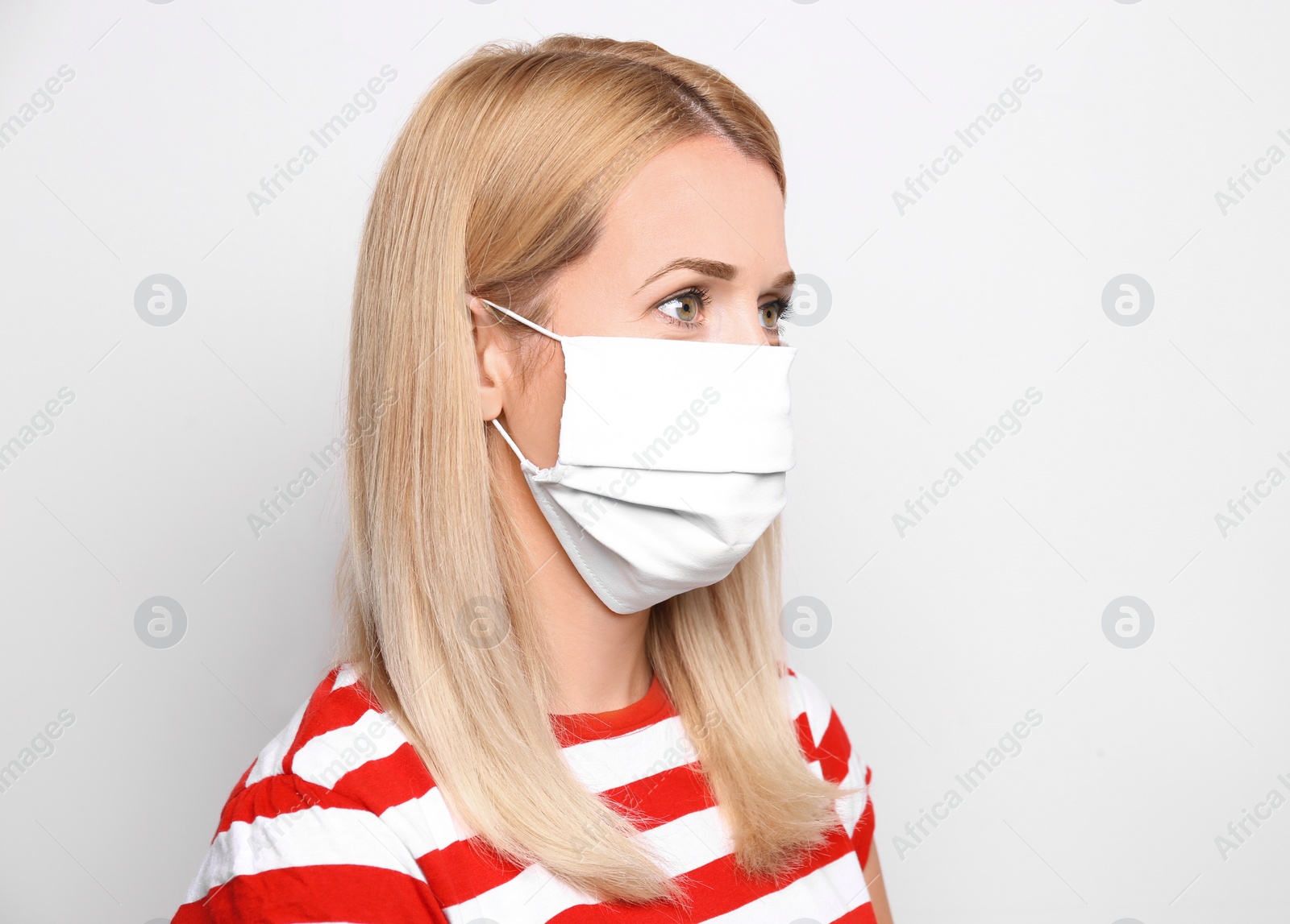 Photo of Woman wearing handmade cloth mask on white background. Personal protective equipment during COVID-19 pandemic