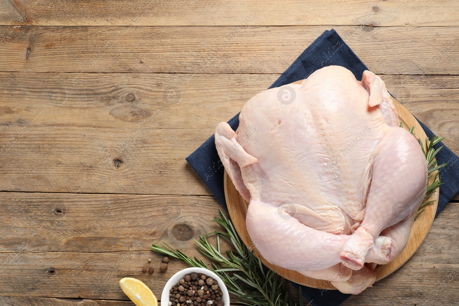 Photo of Fresh raw chicken with spices on wooden table, flat lay. Space for text