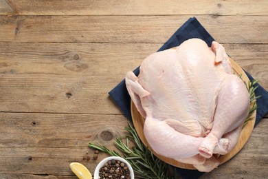 Fresh raw chicken with spices on wooden table, flat lay. Space for text