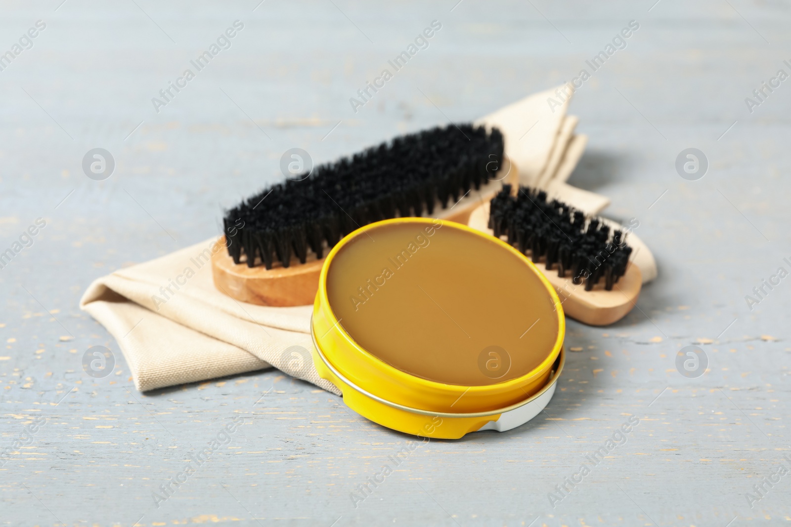 Photo of Shoe care accessories on grey wooden background, closeup