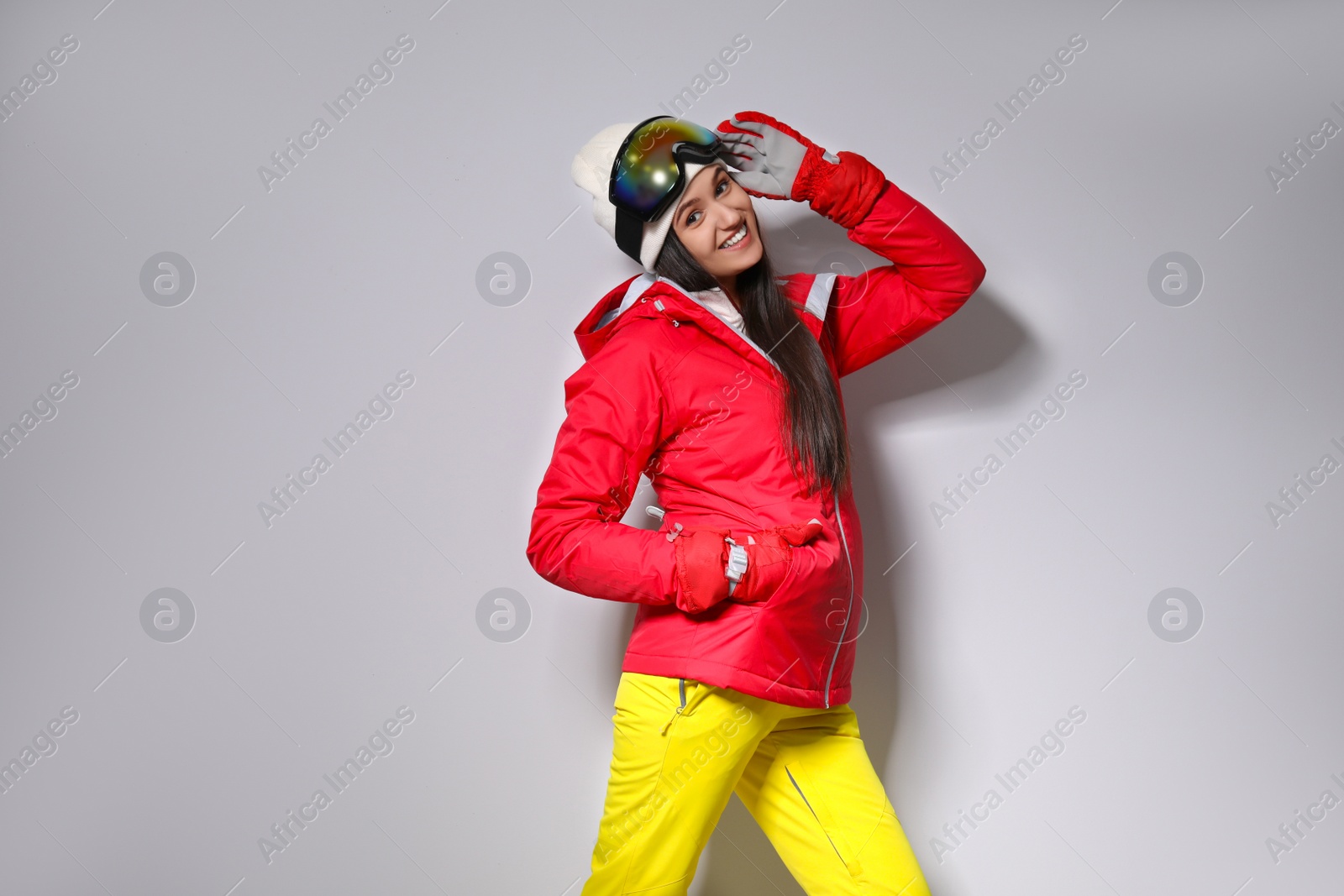 Photo of Woman wearing stylish winter sport clothes on light grey background