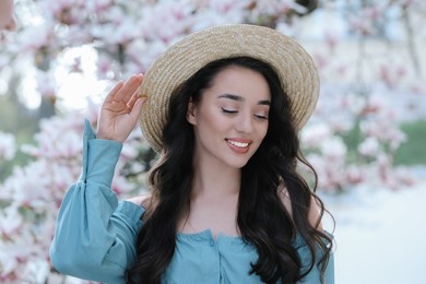 Beautiful woman near blossoming magnolia tree on spring day