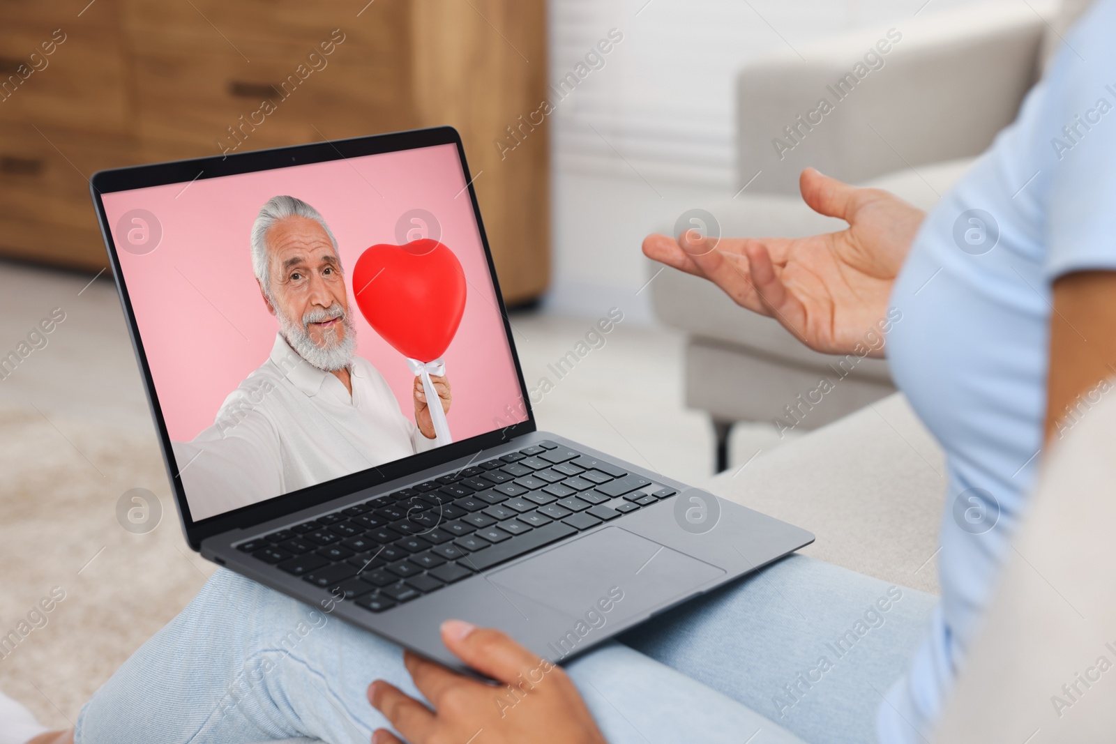 Image of Long distance love. Woman having video chat with her boyfriend via laptop at home, closeup