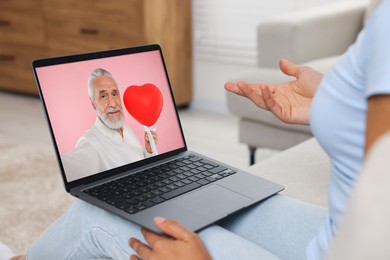Image of Long distance love. Woman having video chat with her boyfriend via laptop at home, closeup