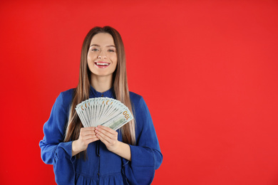 Photo of Young woman with money on crimson background. Space for text