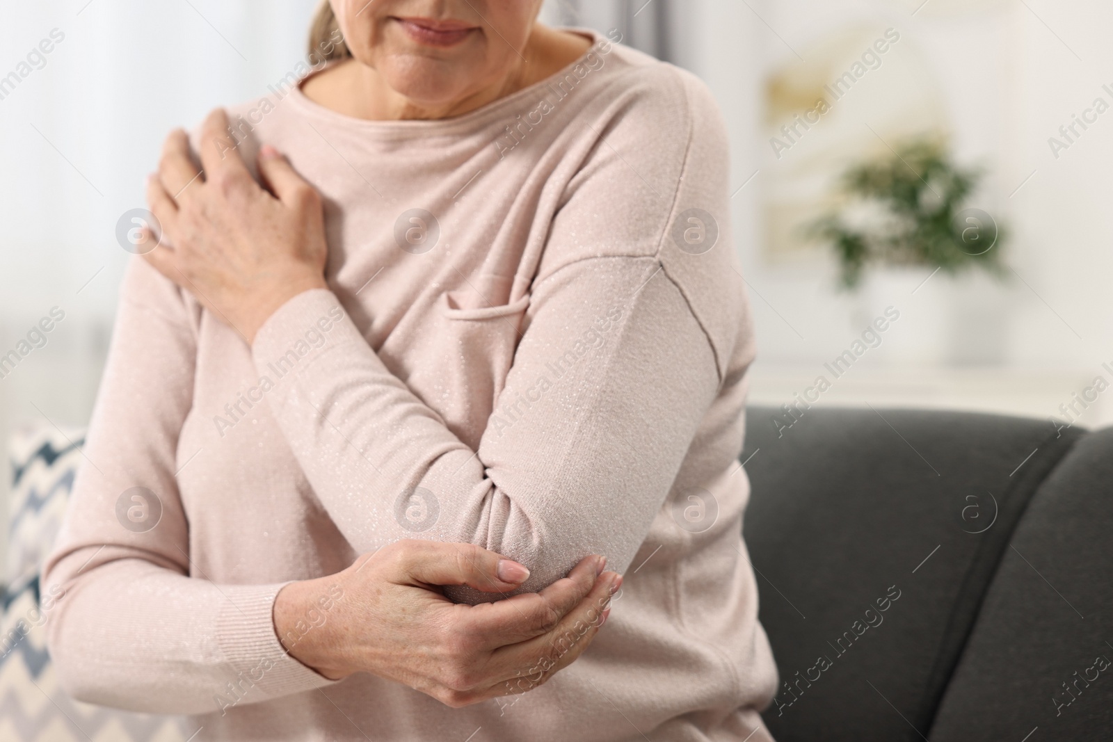 Photo of Arthritis symptoms. Woman suffering from pain in elbow at home, selective focus