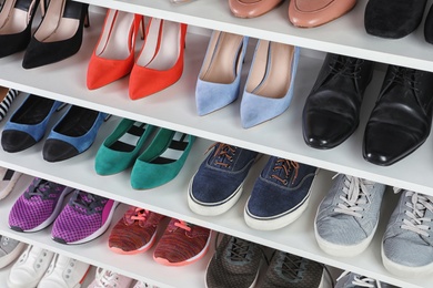 Photo of Shelving unit with different shoes. Element of dressing room interior