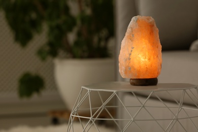 Himalayan salt lamp on table against blurred background