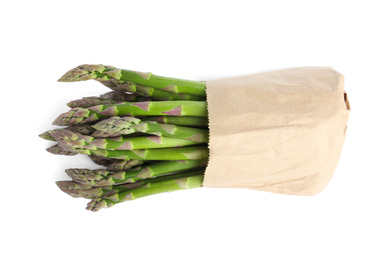 Fresh raw asparagus in paper bag isolated on white. Healthy eating