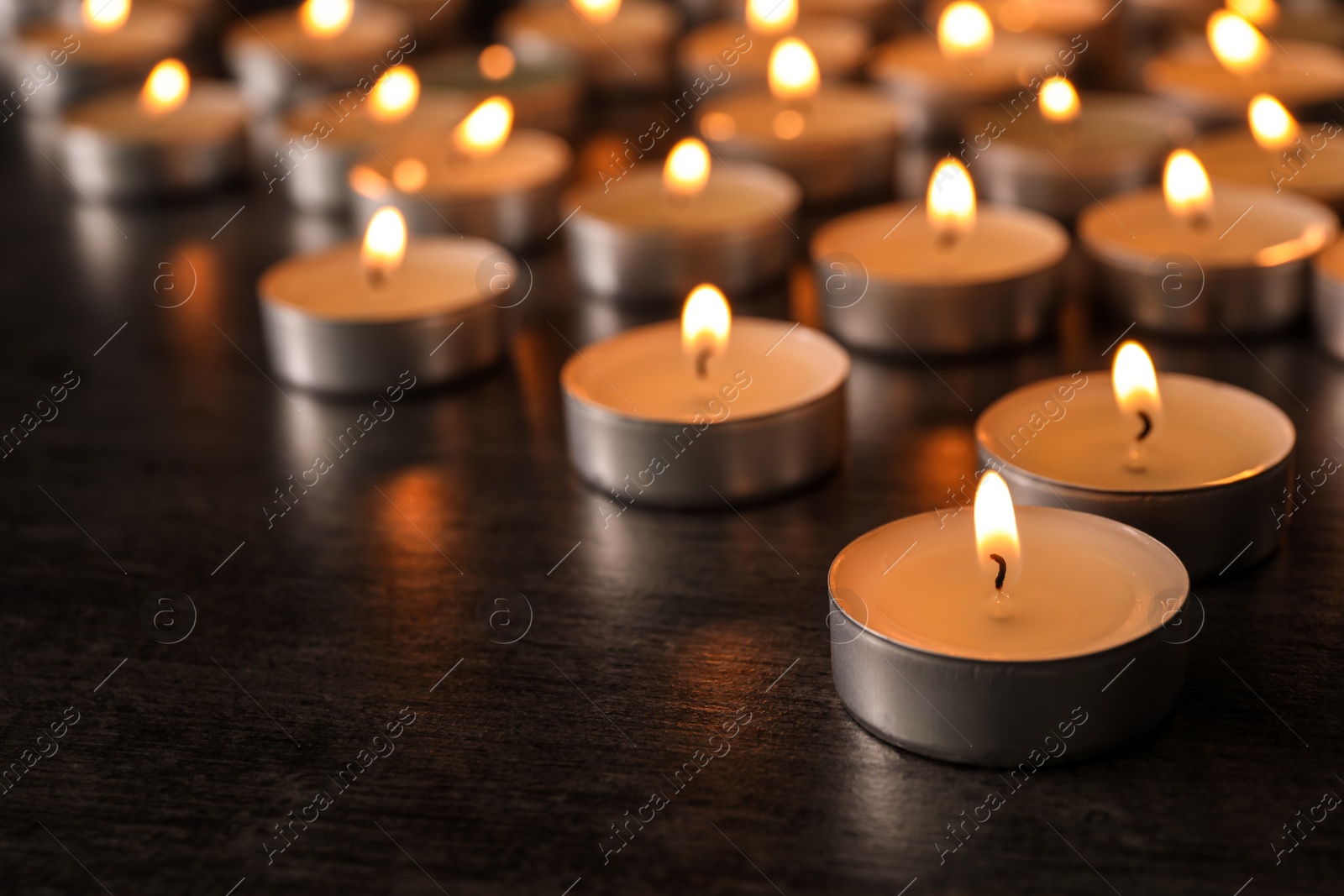 Photo of Burning candles on wooden table, space for text. Symbol of sorrow