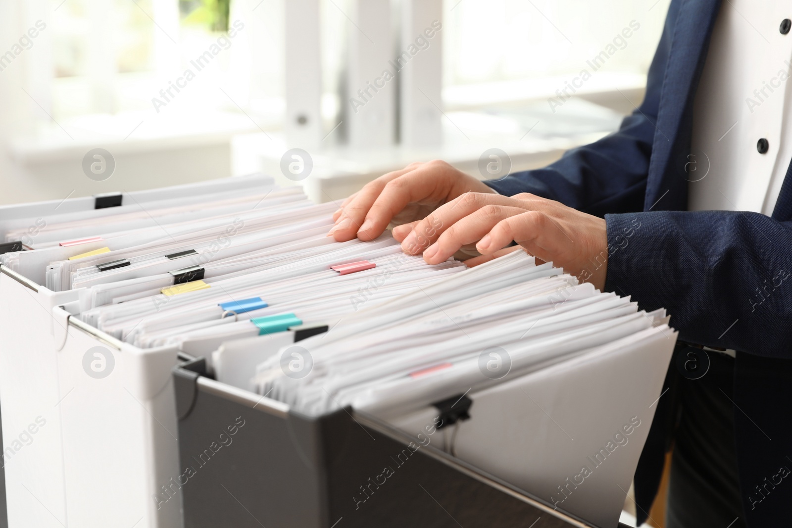 Photo of Woman taking documents from folder in archive, closeup