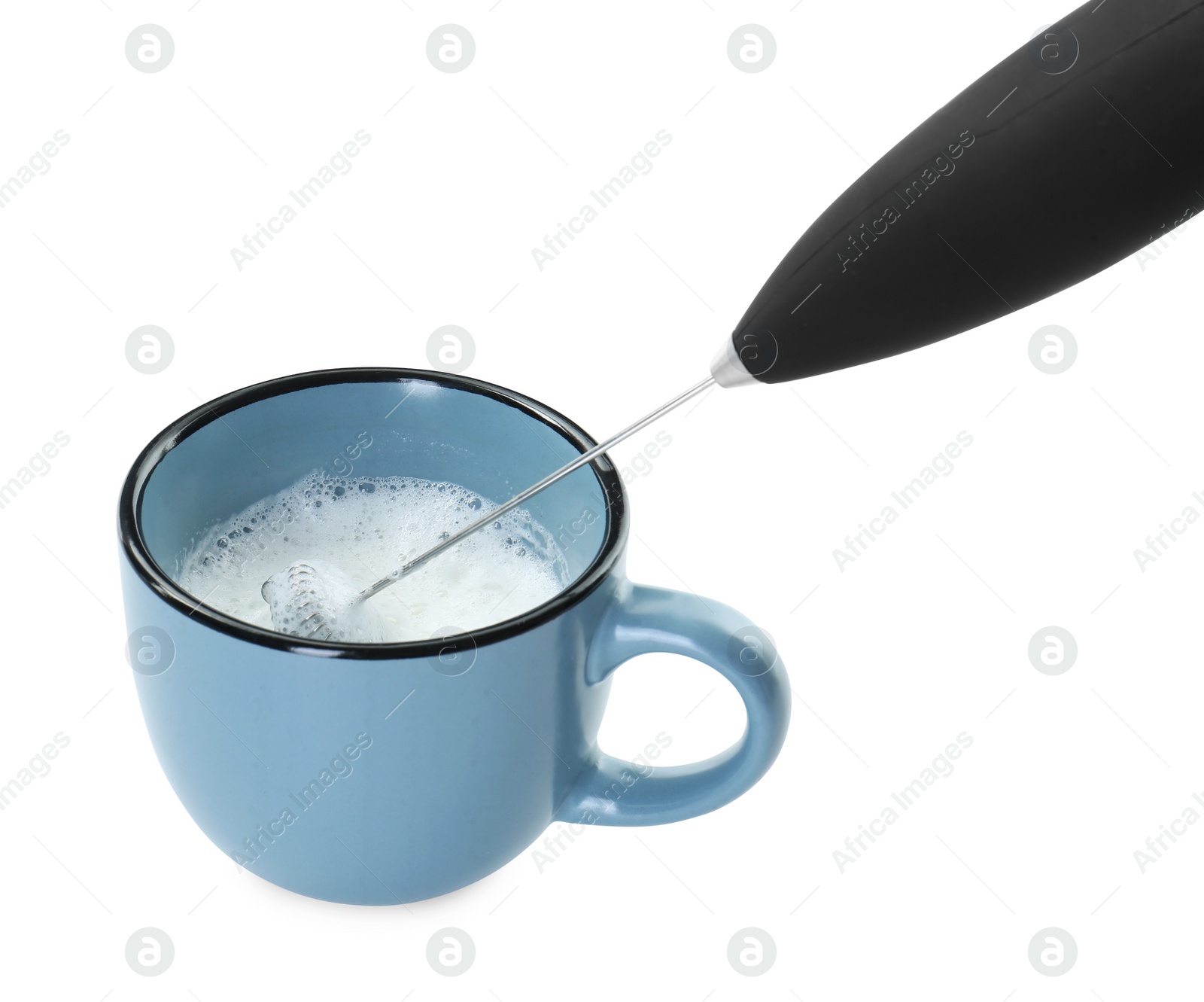 Photo of Whisking milk in cup with mini mixer (frother wand) isolated on white, closeup