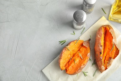 Flat lay composition with baked sweet potatoes on grey background. Space for text